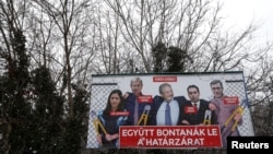 FILE - A government billboard shows George Soros (C) and opposition party leaders in Budapest, Hungary, Feb. 20, 2018. The billboard reads: 'They would dismantle the border fence together'. 