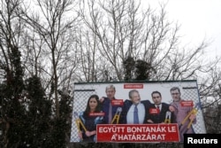 FILE - A government billboard shows George Soros (C) and opposition party leaders in Budapest, Hungary, Feb. 20, 2018. The billboard reads: 'They would dismantle the border fence together'.