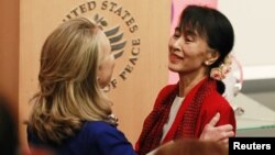 U.S. Secretary of State Hillary Clinton (L) introduces Burma's opposition leader Aung San Suu Kyi to speak at the United States Institute of Peace in Washington, D.C., September 18, 2012. 