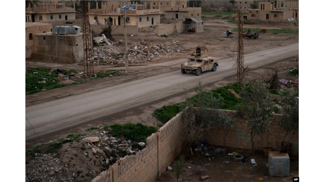A Humvee drives in a village recently retaken from Islamic State militants by U.S.-backed Syrian Democratic Forces near Baghouz, Syria, Feb. 17, 2019.