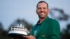 Spain's Sergio Garcia holds the first-place trophy while wearing the winner's green jacket after taking after Masters' title in a playoff, April 9, 2017, in Augusta, Georgia.