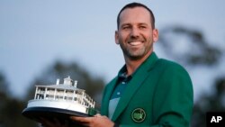 Spain's Sergio Garcia holds the first-place trophy while wearing the winner's green jacket after taking after Masters' title in a playoff, April 9, 2017, in Augusta, Georgia.