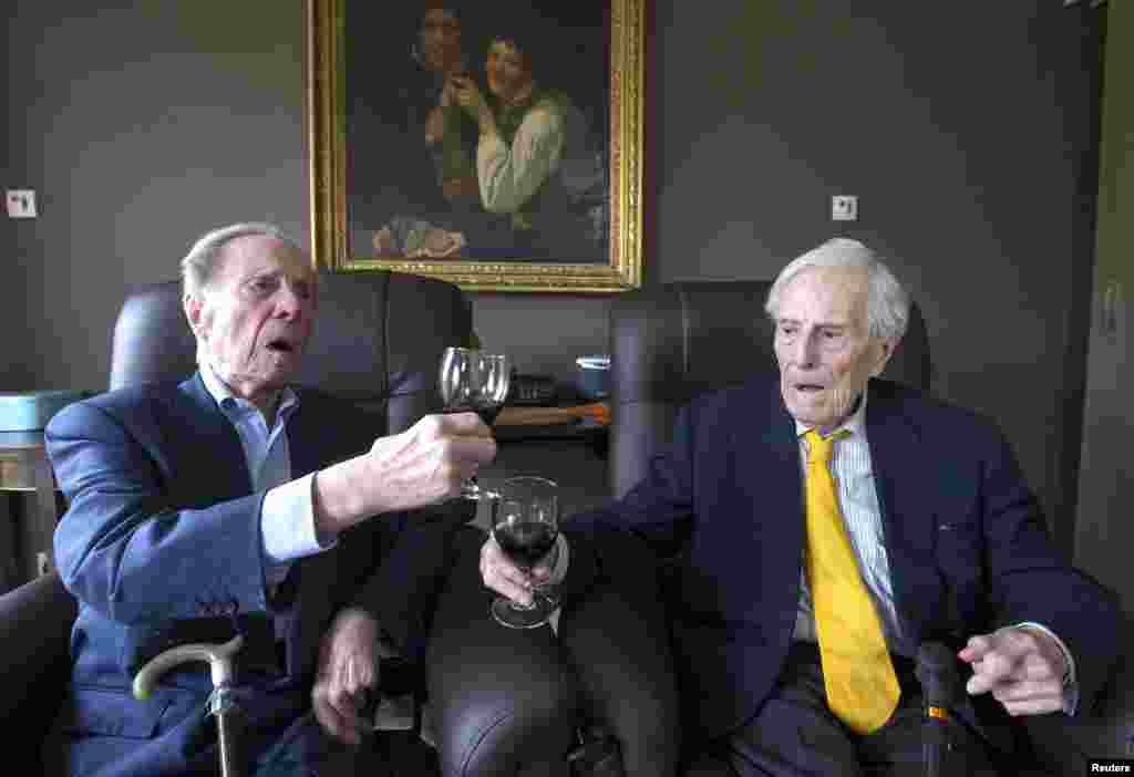 The world&#39;s oldest living twin brothers, Paulus (L) and Pieter Langerock from Belgium, 102, toast while sitting in their living room at the Ter Venne care home in Sint-Martens-Latem, Belgium, Aug.11, 2015.