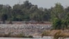 FILE - In this June 20, 2016 photo, a fishing boat passes near a construction site of the Don Sahong dam, near Cambodia-Laos borders, in Preah Romkel village, Stung Treng province, northeast of Phnom Penh, Cambodia.