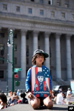 Seorang anak memegang poster dalam pawai unjuk rasa memprotes kebijakan imigrasi Trump di New York, Sabtu, 30 Juni 2018.