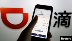 FILE - The app of Chinese ride-hailing giant Didi is seen on a mobile phone in front of the company logo displayed in this illustration picture taken July 1, 2021. (REUTERS/Florence Lo/Illustration/File Photo)