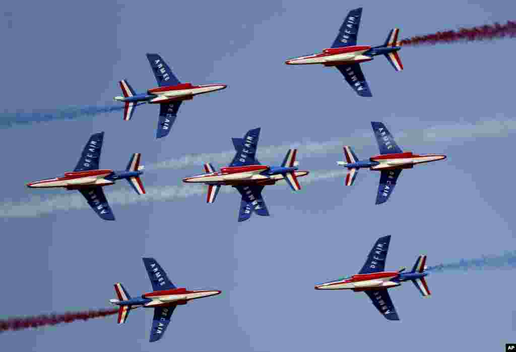 French aircrafts of the Patrouille de France spray colored smoke during a performance on the opening day of the Dubai Airshow in Dubai, United Arab Emirates.
