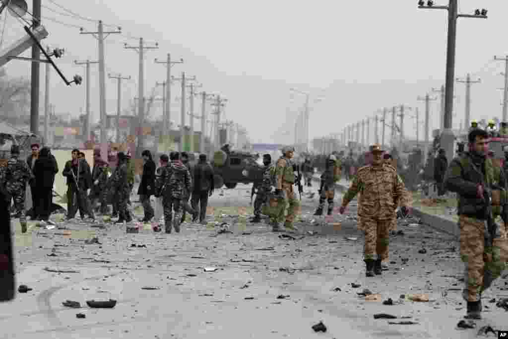 Afghan police and U.S. forces respond to a suicide car bomb attack on the Jalalabad-Kabul road in Kabul, Afghanistan, Dec. 27, 2013.