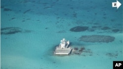 In this photo taken Feb. 28, 2013 by a surveillance plane, and released Thursday, May 15, 2014, by the Philippine Department of Foreign Affairs, Chinese-made structures stands on the Johnson Reef, called Mabini by the Philippines and Chigua by China, in the Spratly Islands in South China Sea.