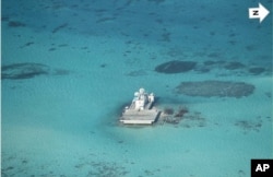 In this photo taken Feb. 28, 2013 by a surveillance plane, and released Thursday, May 15, 2014, by the Philippine Department of Foreign Affairs, Chinese-made structures stands on the Johnson Reef, called Mabini by the Philippines and Chigua by China, in t