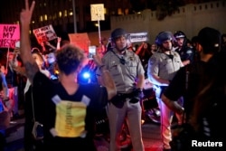 Police are surrounded by demonstrators who took over the Hollywood 101 Freeway just north of Los Angeles City Hall in protest to the election of Republican Donald Trump as President of the United States in Los Angeles, California, Nov. 9, 2016.