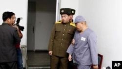American missionary Kenneth Bae, right, leaves after speaking to reporters at Pyongyang Friendship Hospital in Pyongyang Monday, Jan. 20, 2014. 