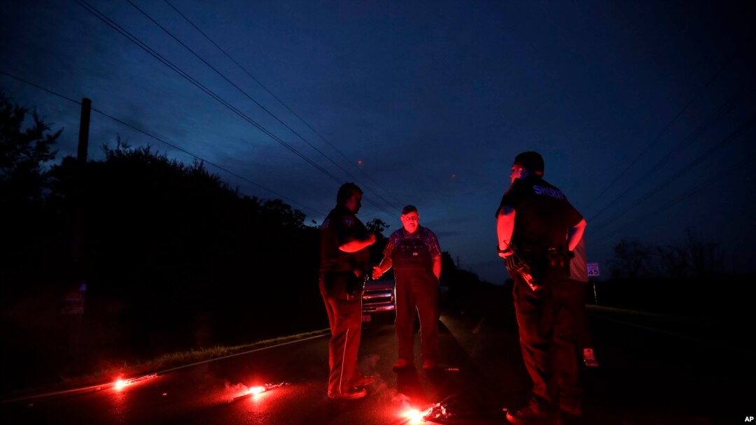 A man talks with officers at a roadblock less than three miles from the Arkema Inc. chemical plant, Aug. 31, 2017, in Crosby, Texas.