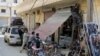 در پی اعلام آتش بس شهروندان حومه حلب برای بازگشایی یک مغازه تلاش میکنند.