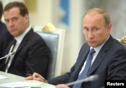 FILE - Russian President Vladimir Putin, right, chairs a meeting on economic and social issues, as Prime Minister Dmitry Medvedev sits nearby, in Moscow, May 7, 2014. Memorial board member Yan Rachinsky says the Russian leaders don't understand that their system of values is helping to revive Stalinism.