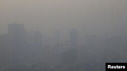 Sebuah konstruksi bangunan di Beijing terlihat berselimut kabut akibat polusi udara, 16 Desember 2016. (Foto: dok). Pada hari tersebut, pihak berwenang China mengeluarkan peringatan merah sebagai tanda tingkat bahaya pencemaran udara akibat terpapar polusi bagi masyarakat di kawasan itu.