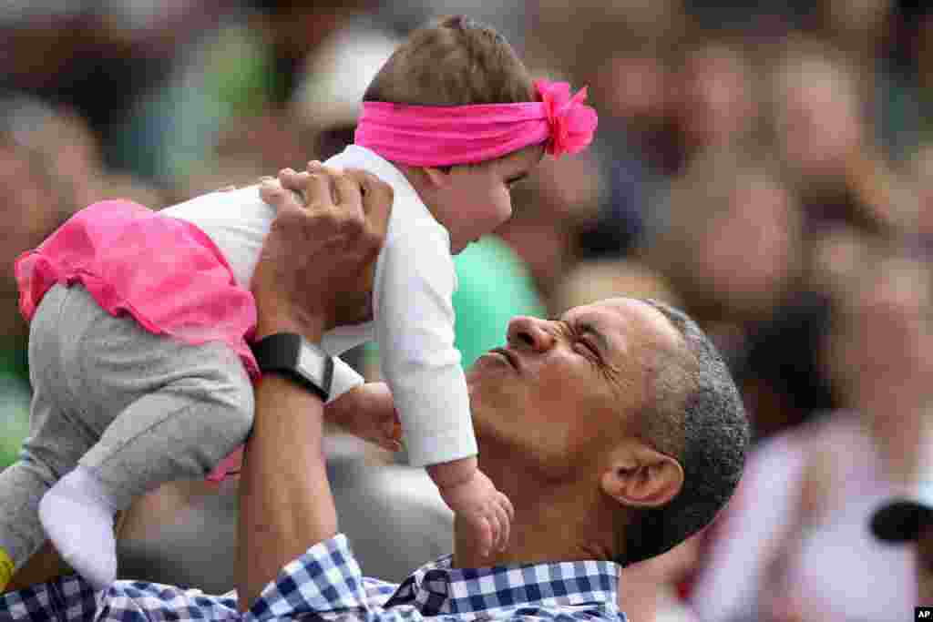 President Barack Obama holds up Stella Muñoz in the air at the egg roll station of the White House Easter Egg Roll in Washington, March 28, 2016. Thousands of children gathered at the White House for the annual Easter Egg Roll. This year&#39;s event features live music, sports courts, cooking stations, storytelling, and Easter egg rolling.