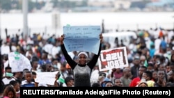 Nigeria, Lagos, A demonstrator holds a sign during protest over alleged police brutality
