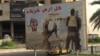 FILE - A poster on a Baghdad street calls for volunteers to join the Hashd al-Shaabi militia, May 18, 2016. Iran might bring this and other Shiite militias in to fight threats to the Tehran government, an Iranian official says. (S. Behn/VOA)