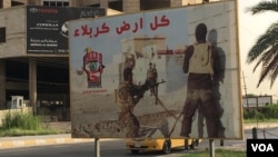 FILE - A poster on a Baghdad street calls for volunteers to join the Hashd al-Shaabi militia, May 18, 2016. Iran might bring this and other Shiite militias in to fight threats to the Tehran government, an Iranian official says. (S. Behn/VOA)