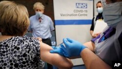英国首相约翰逊观察伦敦一家医院的护士接种新冠病毒疫苗。（2020年12月8日）