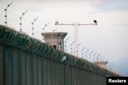 FILE - Security cameras are installed above the perimeter fence of what is officially known as a vocational skills education center in Dabancheng, in Xinjiang Uighur Autonomous Region, China, Sept. 4, 2018.