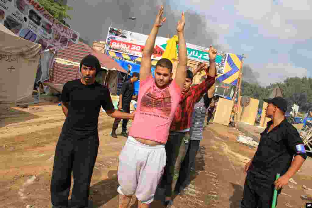 Egyptian security forces detain protesters as they clear a sit-in by supporters ousted Islamist President Mohammed Morsi in the eastern Nasr City district of Cairo, Egypt, Aug. 14, 2013. 