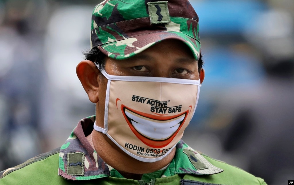 Indonesia: Un soldado usa una curiosa máscara mientras hace guardia en un puesto de control. El gobierno ha impuesto una cuarentena masiva con el objetivo&nbsp;de frenar la propagación del brote de coronavirus en Yakarta. La capital de Indonesia inició duras restricciones ya que el área metropolitana se ha convertido en el epicentro de coronavirus de Indonesia.