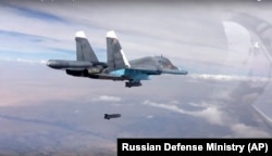 FILE - A bomb is released from Russian Su-34 strike fighter in Syria, Oct. 9, 2015.