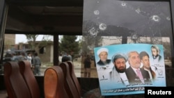 Một tấm poster vận động bầu cử của ứng viên tổng thống Afghanistan Abdullah Abdullah trên tấm gương của một xe buýt bị hỏng sau vụ đánh bom. 