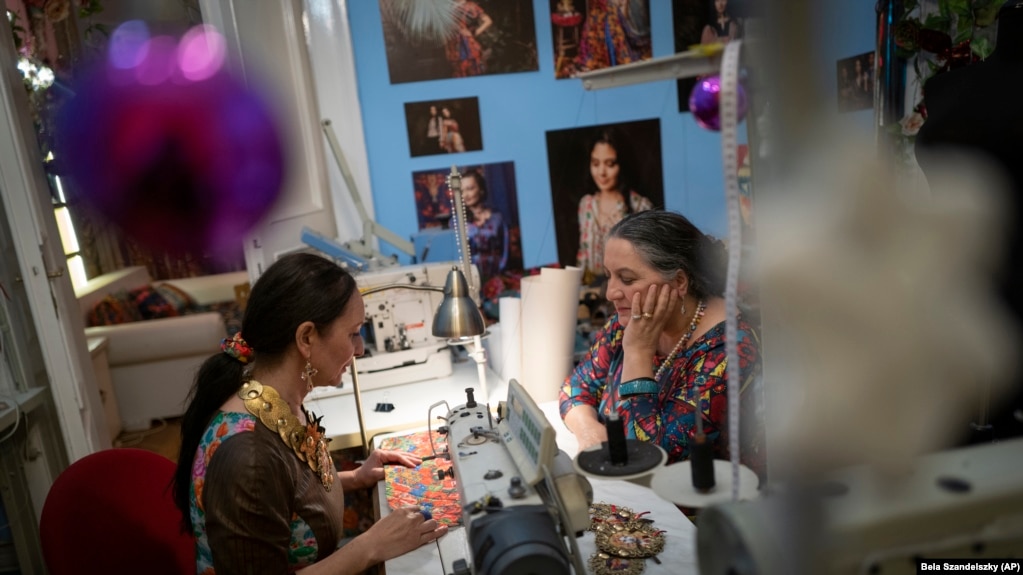 Roma sisters Helena, left, and Erika Varga work on a production in their fashion studio, Romani Design, in Budapest, Hungary, December 12, 2021. (AP Photo/Bela Szandelszky)