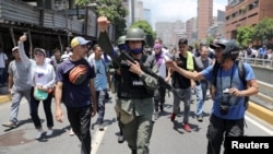 A Venezuelan National Guard joins anti-government protesters in a march showing support for opposition leader Juan Guaido in Caracas, Venezuela April 30, 2019.