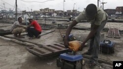 FILE - Due to Nigeria's decrepit national power grid, a man refuels a small generator in central Lagos, Nigeria, August 2010.