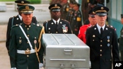 FILE - U.N. honor guards carry a coffin containing the remains of an American soldier after they were returned by North Korea, at the border village of Panmunjom, South Korea, May 14, 1999.