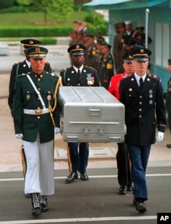 FILE - U.N. honor guards carry a coffin containing the remains of an American soldier after they were returned by North Korea, at the border village of Panmunjom, South Korea, May 14, 1999.