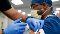 FILE - In this Oct. 5, 2021, photo, a health care worker receives a Pfizer COVID-19 booster shot at Jackson Memorial Hospital in Miami.