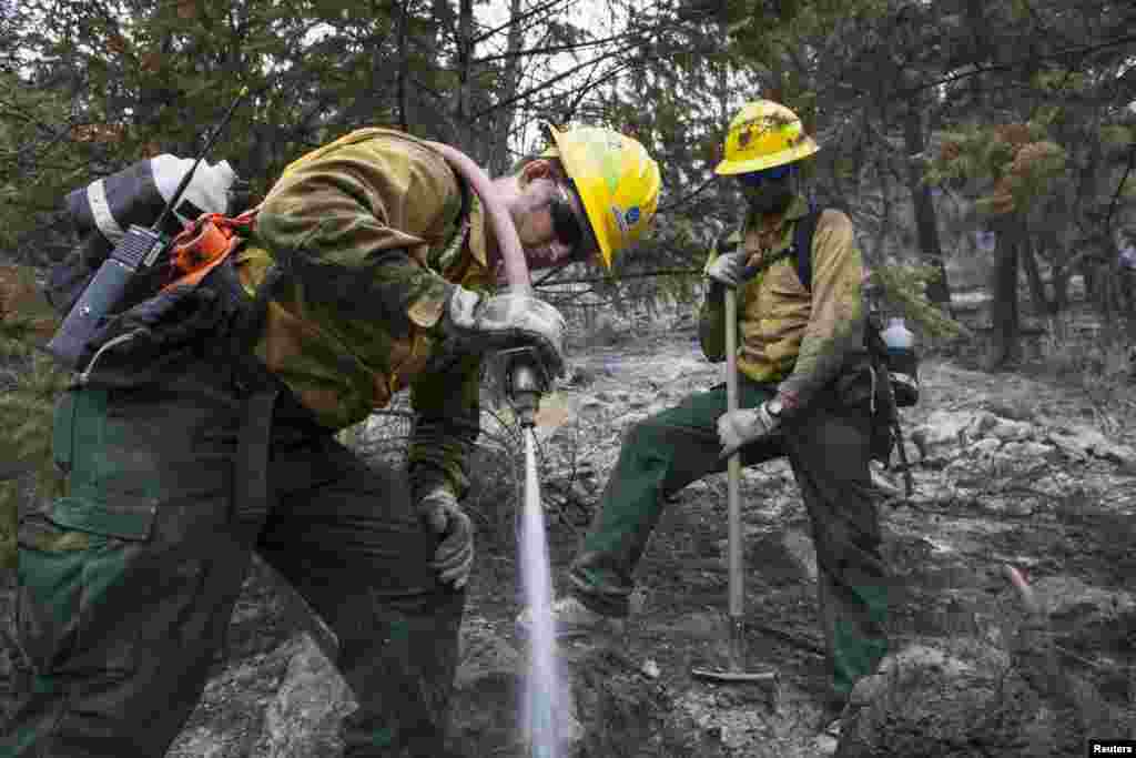 Firefighters extinguish hot spots in an area burned by the Chelan Complex fire in Chelan, Aug. 24, 2015.