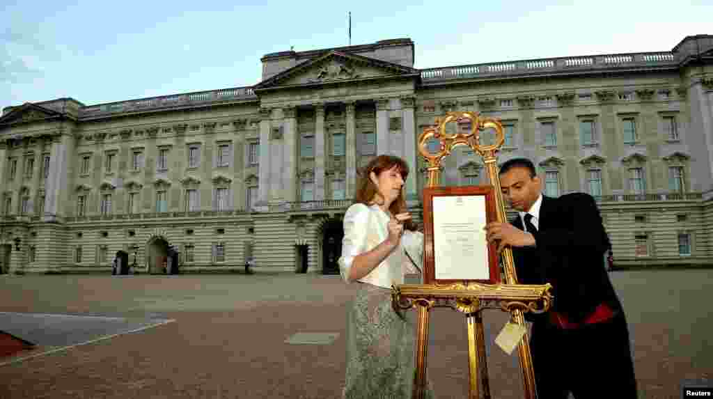 La secretaria de prensa de la Reina Isabel II, Ailsa Anderson y el funcionario de la corona, Badar Azim, presentan el documento de nacimiento del príncipe de Cambridge ante el público.