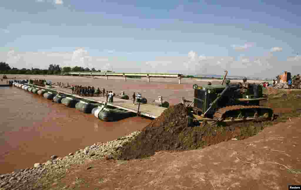 Indian Army soldiers completing a temporary bridge across the Tawi river, Sept. 9, 2014.