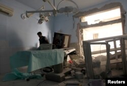 FILE - A medic inspects the damage inside Anadan Hospital, sponsored by Union of Medical Care and Relief Organizations (UOSSM), after it was hit by an airstrike in the rebel-held city of Anadan, northern Aleppo province, Syria, July 31, 2016.