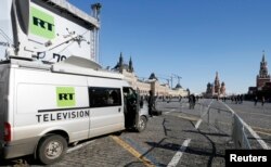 FILE - Vehicles of Russian state-controlled broadcaster Russia Today (RT) are seen at Red Square in central Moscow, March 18, 2018.