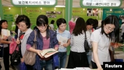 한국 서울에서 열린 여성 취업박람회에서 구직자들이 직업 훈련 센터에서 제공하는 유인물을 들여다보고 있다. (자료사진)