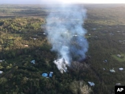 In this photo released by U.S. Geological Survey, lava is shown burning in Leilani Estates subdivision near the town of Pahoa on Hawaii's Big Island, May 3, 2018, in Hawaii Volcanoes National Park. Kilauea volcano erupted Thursday, prompting mandatory evacuations.