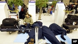 Passengers wait for their flights in a terminal after sleeping a night at the Charles-de-Gaulle Roissy airport, Paris, 24 Dec 2010