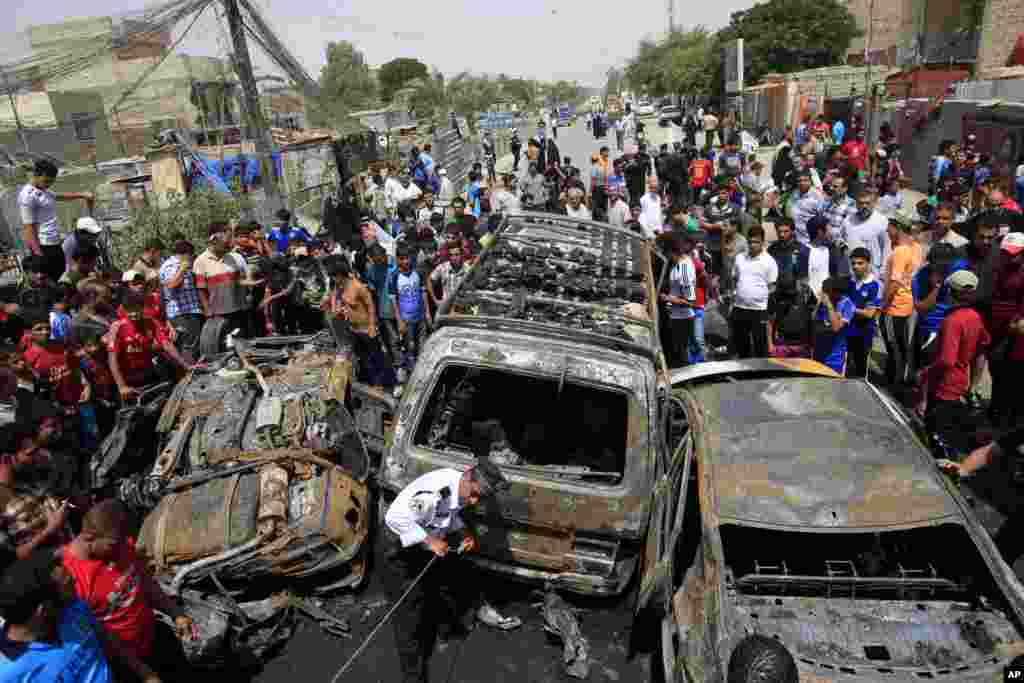 People gather at the scene of a car bomb attack in the Sadr City neighborhood in Baghdad, May 16, 2013. 