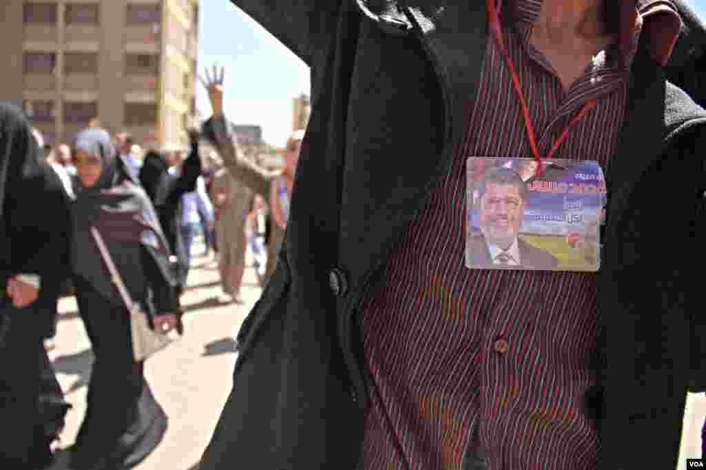 A protester wears an image of ousted President Mohamed Morsi during a demonstration in Cairo, March 28, 2014. (Hamada Elrassam/VOA)