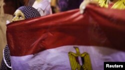 A girl holds Egypt's flag as she attends a sit-in protest organized by supporters of the deposed Egyptian President Mohamed Morsi, Cairo, July 11, 2013.