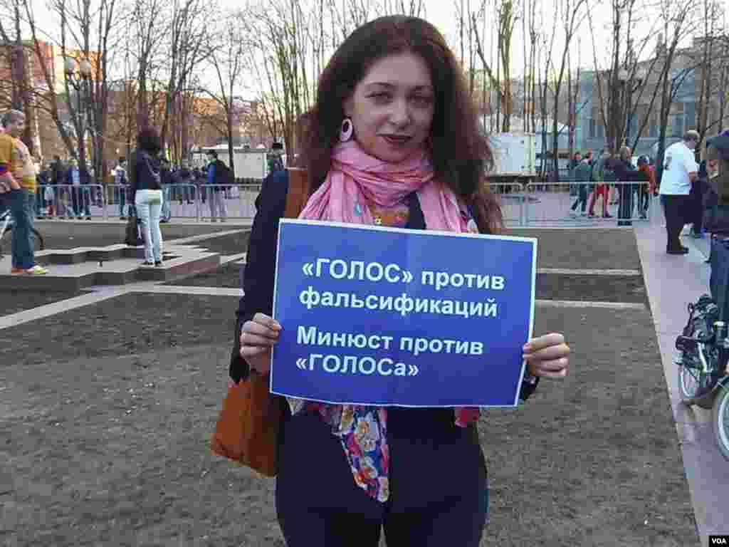 监督选举的人权机构“戈洛斯”志愿者奥莉加。她手中的标语是：“戈洛斯”反对选举舞弊，但司法部却反对“戈洛斯”，4月17日莫斯科支持纳瓦里内集会。（美国之音白桦拍摄）