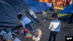 En la foto de archivo dos niños, que fueron devueltos luego de que la petición de asilo de su padre fuera rechazado, juegan en Ciudad Juárez, México, el 13 de diciembre de 2019.