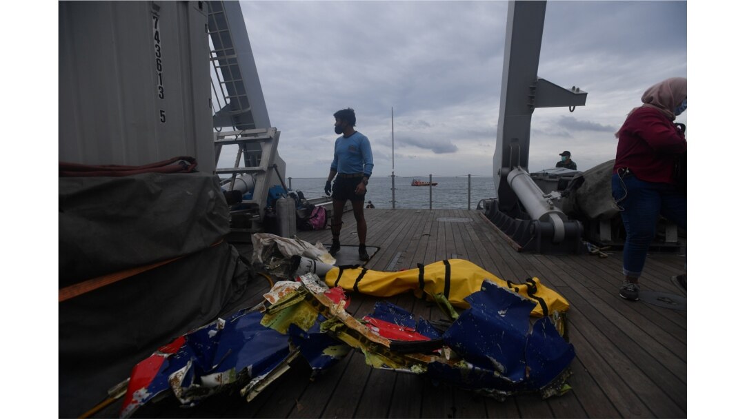 TNI AL berdiri di dekat kantong jenazah yang diyakini sebagai sisa-sisa pesawat Sriwijaya Air Flight SJ182 yang jatuh ke laut di Jakarta, 10 Januari 2021. (Foto: Antara/Sigid Kurniawan via REUTERS)